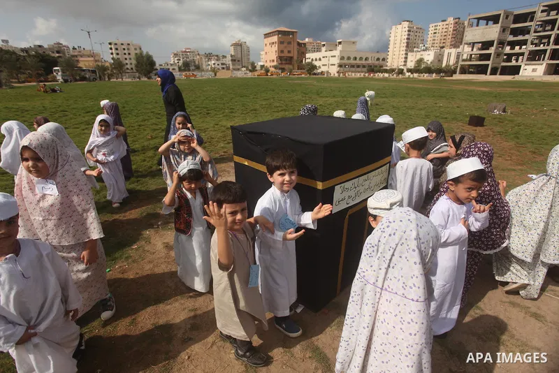 Palestinian children gather around a makeshift cube representing the holy Kaaba in Gaza city, on Sept. 21, 2015, as part of training children how to perform Hajj pilgrimage. Muslims from around the world flood Saudi city...