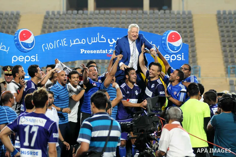 El-Zamalek Chairman Mortada Mansour and players celebrate with the trophy after winning their Egyptian Cup finals derby soccer match against Al-Ahly at Petro Sport stadium in Cairo, Egypt, September 21, 2015. Photo by St...