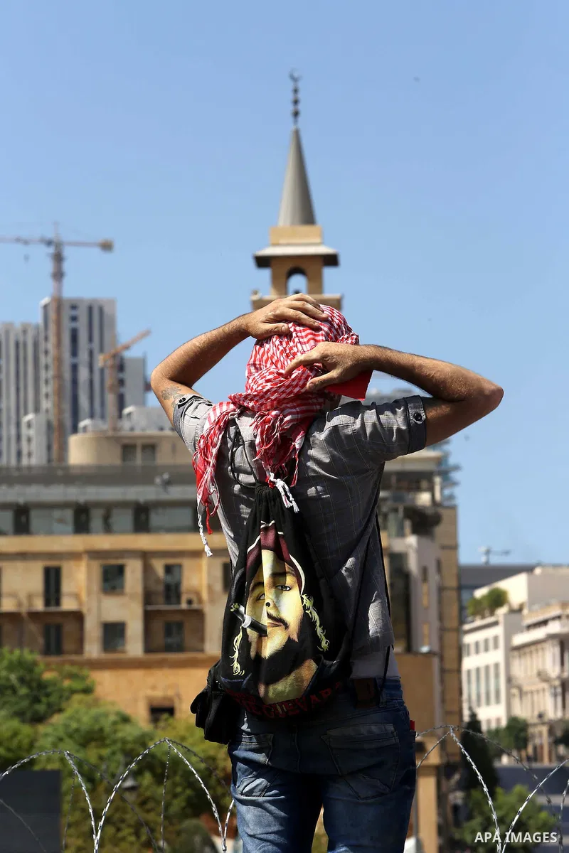 Lebanese anti-government protesters take part in a protest on a road leading to the parliament, where leading figures of Lebanon's main political parties meet for the third time in an effort to end the paralysis plaguing...