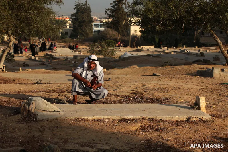 A Palestinian man prays over the graves of relatives in a cemetery, on the Muslim holiday of Eid al-Adha or or the feast of sacrifice, in Khan Younis in the southern Gaza Strip on September 24, 2015. Muslims across the w...