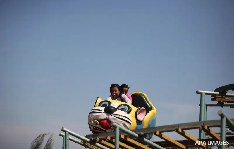 Palestinians play at an amusement park during the fourth day of Eid al-Adha or "Feast of the sacrifice" in Gaza City on September 27, 2015. Muslims across the world are celebrating the annual festival of Eid al-Adha whic...