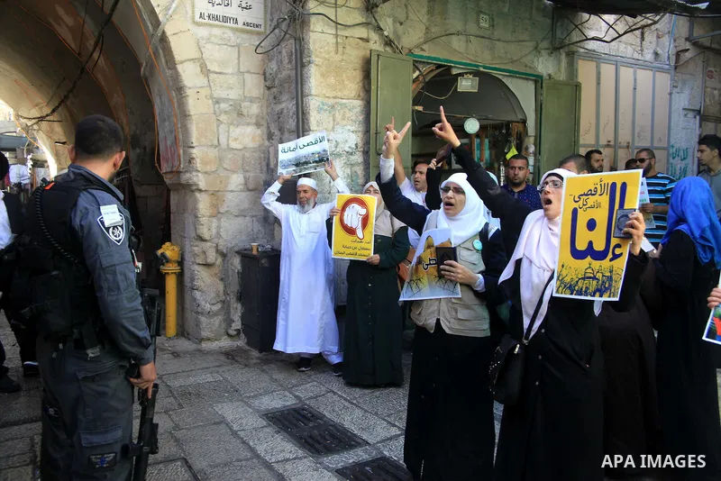 Palestinian women from the so-called Murabitat group carry placards and shout slogans in front of Israeli security forces during a protest against Jewish groups visiting the Al-Aqsa mosque compound and against preventing...