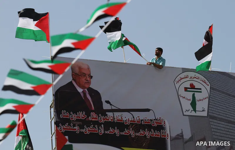 A Palestinian man hangs his national flag, during an event to support Palestinian President Mahmoud Abbas in the West Bank city of Nablus on September 30, 2015. Abbas has circulated a hard-hitting critique of alleged Isr...