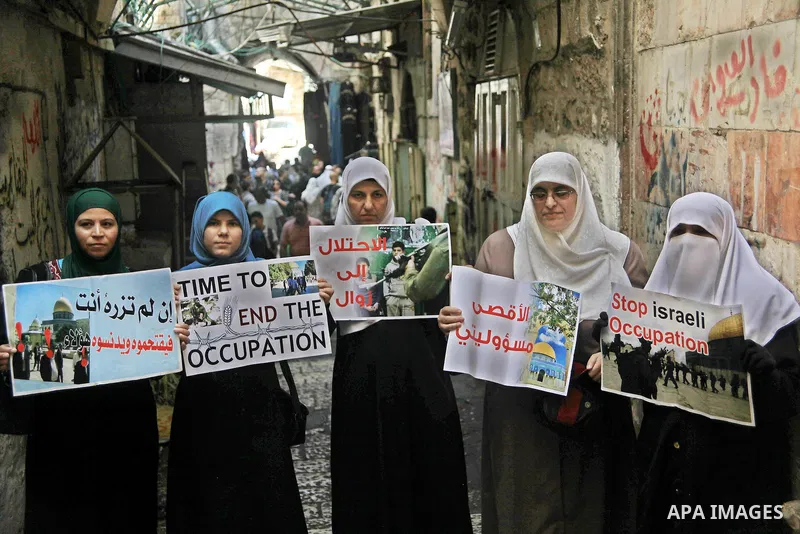 Palestinian women from the so-called Murabitat group carry placards and shout slogans in front of Israeli security forces during a protest against Jewish groups visiting the Al-Aqsa mosque compound and against preventing...