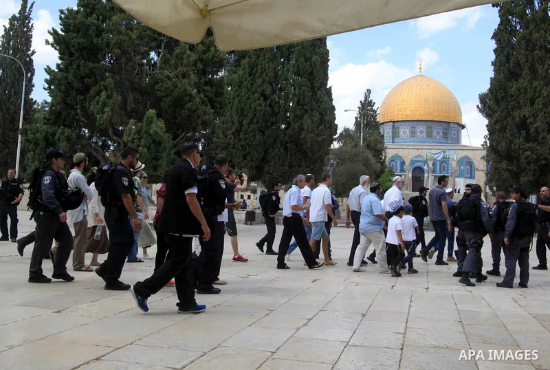 Israeli Jewish settlers walk with Israeli police in front of the Dome of the Rock mosque in Jerusalem's old city on September 30, 2015. Photo by Mahfouz Abu Turk