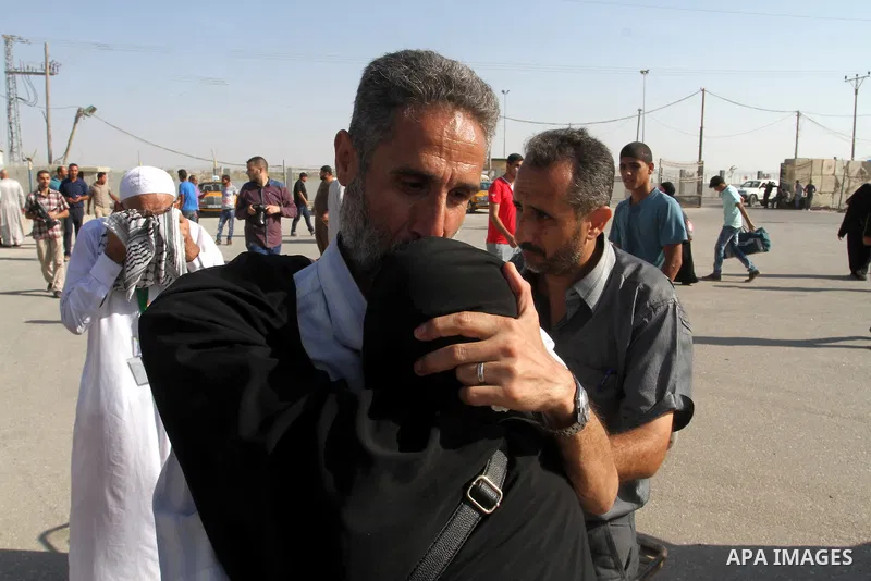 A Palestinian man welcomes his pilgrim relative at the Rafah crossing between Gaza Strip and Egypt after performing the annual Hajj, in Rafah in southern Gaza Strip, September 30, 2015. Around 500 Hajj pilgrims cross Raf...