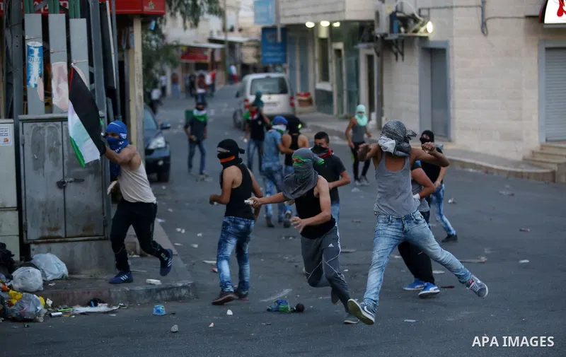 Palestinian protesters throw stones towards Israeli security forces during clashes over the Al-Aqsa mosque compound, close to the Israeli manned checkpoint of Hezma in the Israeli occupied West Bank, between Jerusalem an...