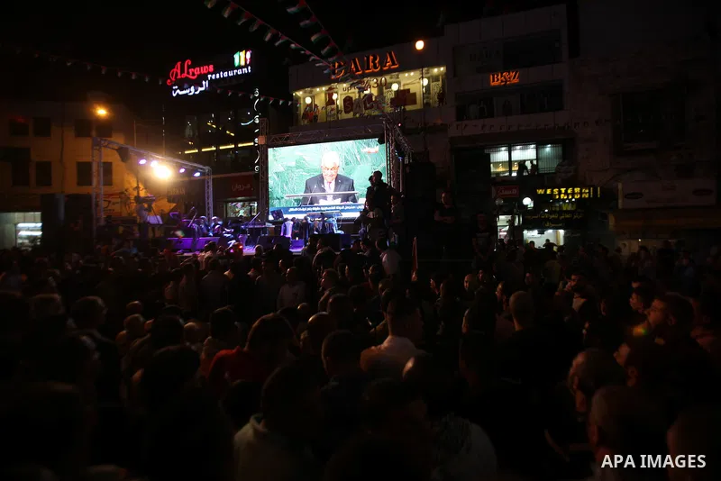 Palestinians watch a live-screening of president Mahmoud Abbas' speech followed by the raising of the Palestinian flag at the United Nations headquarters in New York, in the West Bank city of Nablus on September 30, 2015...