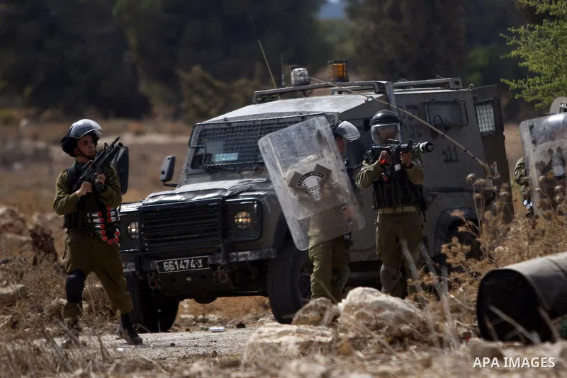A member of Israeli security forces fires tear gas towards Palestinian protesters during clashes in Budrus village, west of Ramallah on October 2, 2015. Two Israeli settlers were shot and killed in a drive-by shooting be...