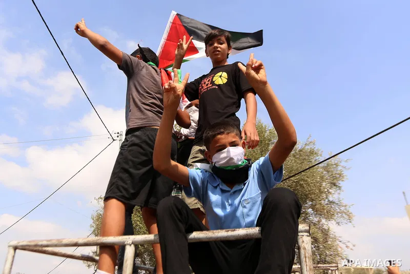 Palestinian protesters wave their national flags during clashes with Israeli security forces in Budrus village, west of Ramallah on October 2, 2015. Two Israeli settlers were shot and killed in a drive-by shooting betwee...