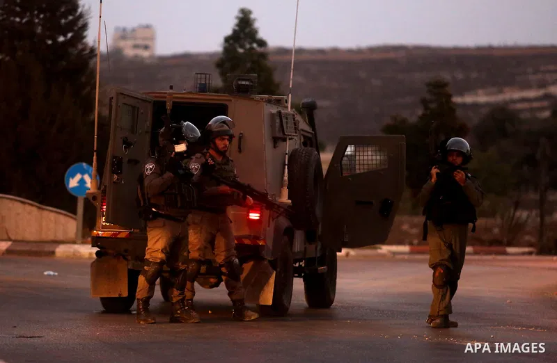 Israeli soldiers take position during clashes with Palestinian protesters close to the Jewish settlement of Bet El, in the West Bank city of Ramallah on October 4, 2015 after Israel barred Palestinians from Jerusalem's O...