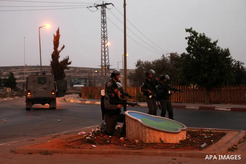 Israeli soldiers take position during clashes with Palestinian protesters close to the Jewish settlement of Bet El, in the West Bank city of Ramallah on October 4, 2015 after Israel barred Palestinians from Jerusalem's O...