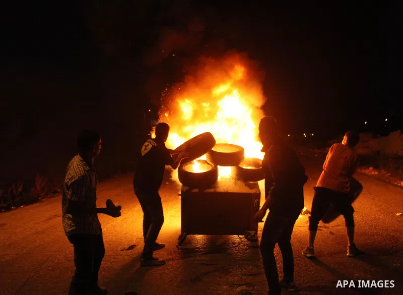 Palestinian protesters burn tyres during clashes with Israeli soldiers close to the Jewish settlement of Bet El, in the West Bank city of Ramallah on October 4, 2015 after Israel barred Palestinians from Jerusalem's Old...