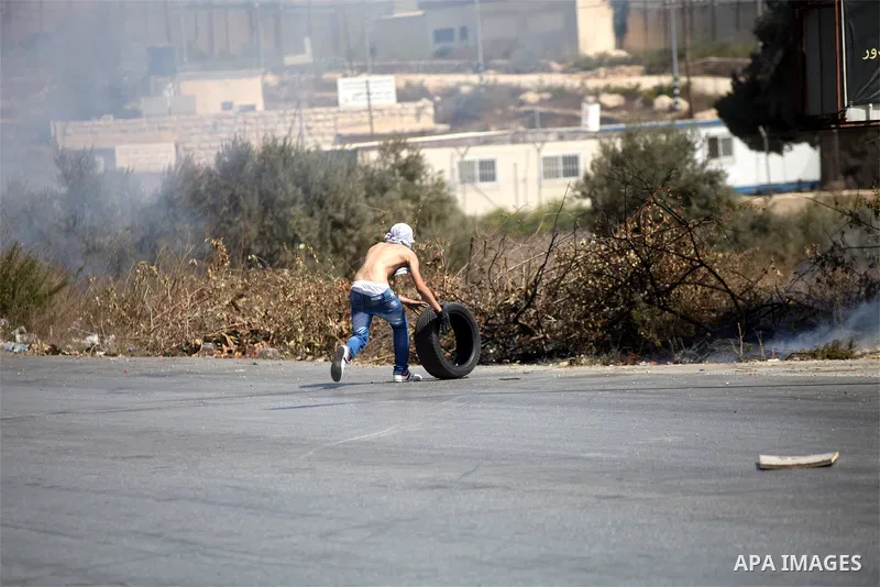 A Palestinian protester burns tires during clashes with Israeli troops near the Jewish settlement of Bet El, near the occupied West Bank city of Ramallah October 5, 2015. Violence intensified in Jerusalem and the West Ba...
