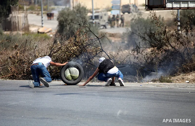 Palestinian protesters take cover during clashes with Israeli troops near the Jewish settlement of Bet El, near the occupied West Bank city of Ramallah October 5, 2015. Violence intensified in Jerusalem and the West Bank...