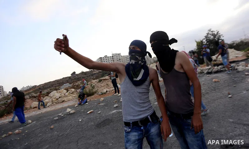 Palestinian protester take a selfie during clashes with Israeli troops near the Jewish settlement of Bet El, near the occupied West Bank city of Ramallah October 5, 2015. Violence intensified in Jerusalem and the West Ba...