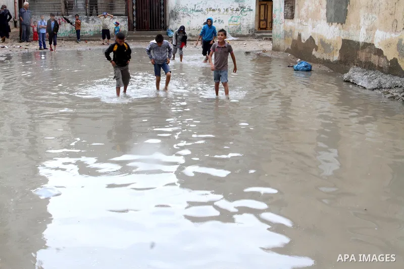 Palestinian children walk in a flooded street following heavy rains in Khan Younis in the southern Gaza Strip, October 7, 2015. Photo by Abed Rahim Khatib