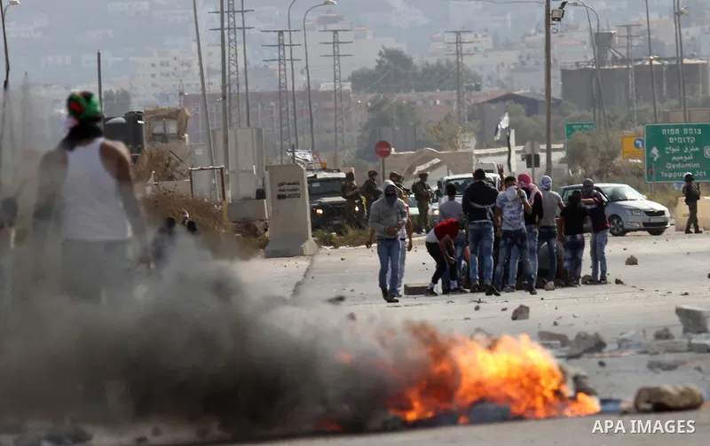 Palestinian protesters throw stones towards Israeli security forces during clashes at the Howara checkpoint near the West Bank city of Nablus, October 9, 2015. Tension and protests rose after an Israeli man on 09 October...