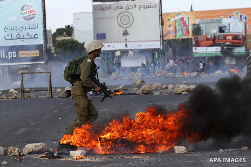A member of Israeli security forces runs after Palestinian protesters during clashes at the Howara checkpoint near the West Bank city of Nablus, October 9, 2015. Tension and protests rose after an Israeli man on 09 Octob...