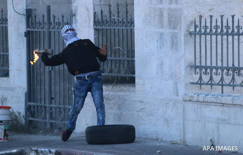 A Palestinian protester throws a molotov cocktail towards Israeli security forces during clashes in the West Bank town of Bethlehem on October 9, 2015. Tension and protests rose after an Israeli man on 09 October stabbed...