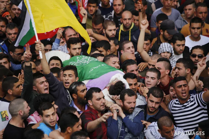 Mourners carry the body of Palestinian Mohammed Jabari, who stabbed an Israeli policeman before being shot dead on Friday, in the West Bank city of Hebron October 10, 2015. Fifteen Palestinians have been killed by Israel...