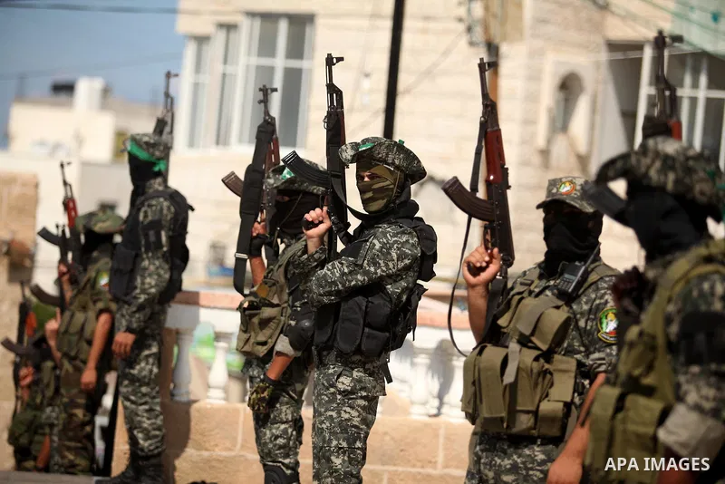 Palestinian militants of the Ezzedine al-Qassam Brigades, Hamas' armed wing, attend the funeral of 22-year-old Jihad al-Obeid, who died in clashes with Israeli security forces near the border, in Deir al-Balah, in the ce...
