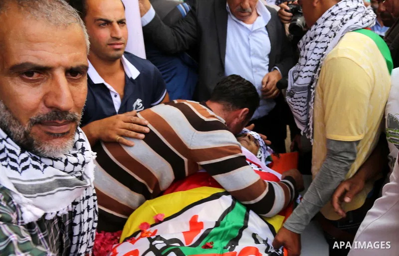 Relatives of Palestinian Amjad Al-joundi, mourn around his body during his funeral, in the Yatta, south of the West Bank city of Hebron October 10, 2015. Fifteen Palestinians have been killed by Israeli forces and around...