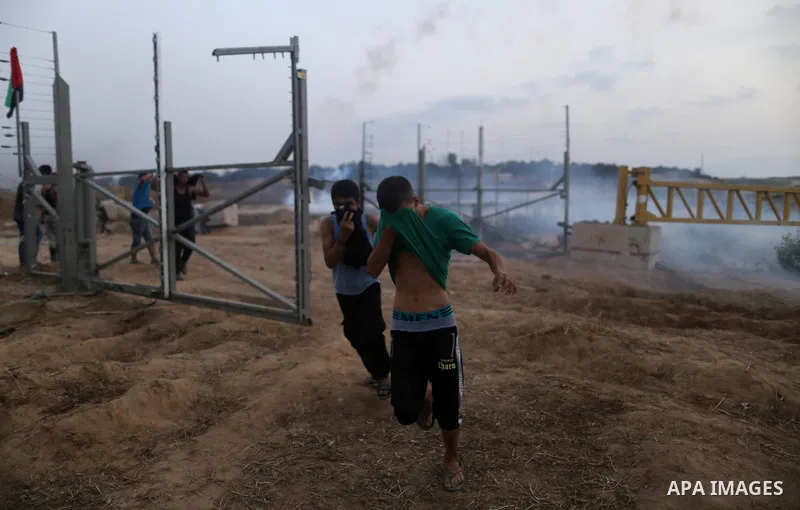 Palestinian protestors gather after tearing down a section of a border fence between Israel and the Gaza Strip during clashes with Israeli security forces on October 12, 2015, east of Bureij in central Gaza. Palestinian...