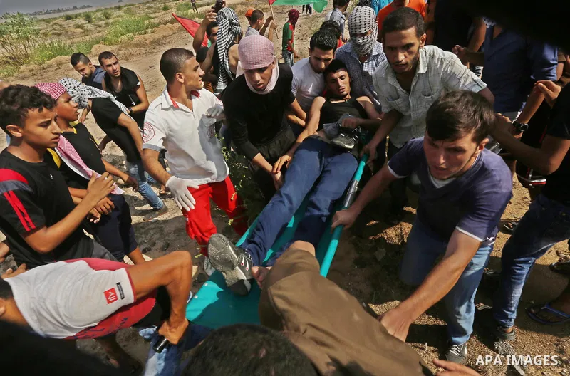 A Palestinian protester is evacuated by comrades after being injured during clashes with Israeli security forces near the Erez border crossing between Israel and northern Gaza Strip on October 13, 2015. A wave of stabbin...