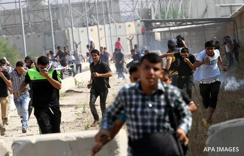 Palestinian protesters run for cover during clashes with Israeli security forces near the Erez border crossing between Israel and northern Gaza Strip on October 13, 2015. A wave of stabbings that hit Israel, Jerusalem an...