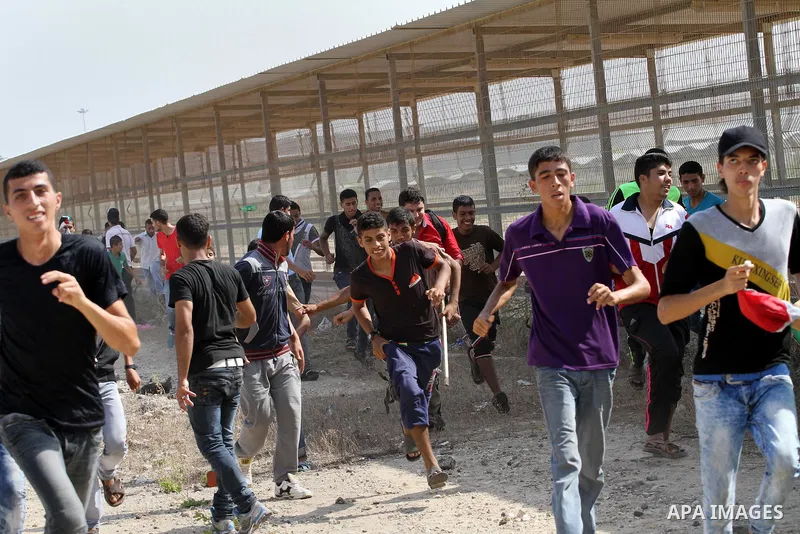 Palestinian protesters run for cover during clashes with Israeli security forces near the Erez border crossing between Israel and northern Gaza Strip on October 13, 2015. A wave of stabbings that hit Israel, Jerusalem an...
