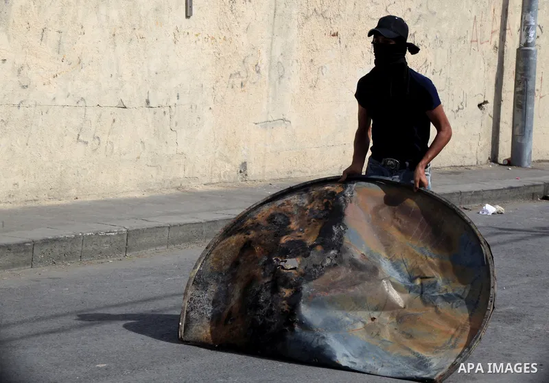 A Palestinian protester takes cover during clashes with Israeli police in Jabal al-Mukaber neighborhood, southern Jerusalem, on October 13, 2015. A wave of stabbings that hit Israel, Jerusalem and the West Bank this mont...