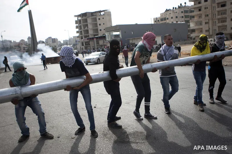 Palestinian protesters set barricades during clashes with Israeli security forces near the Jewish settlement of Bet El, near the West Bank city of Ramallah, on October 13, 2015. A wave of stabbings that hit Israel, Jerus...