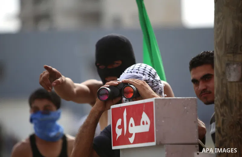 A Palestinian protester looks through binoculars during clashes with Israeli security forces near the Jewish settlement of Bet El, near the West Bank city of Ramallah, on October 13, 2015. A wave of stabbings that hit Is...