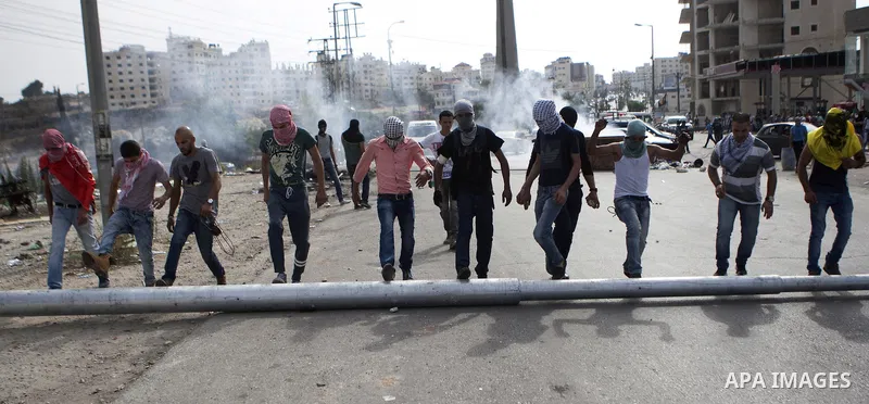 Palestinian protesters set barricades during clashes with Israeli security forces near the Jewish settlement of Bet El, near the West Bank city of Ramallah, on October 13, 2015. A wave of stabbings that hit Israel, Jerus...