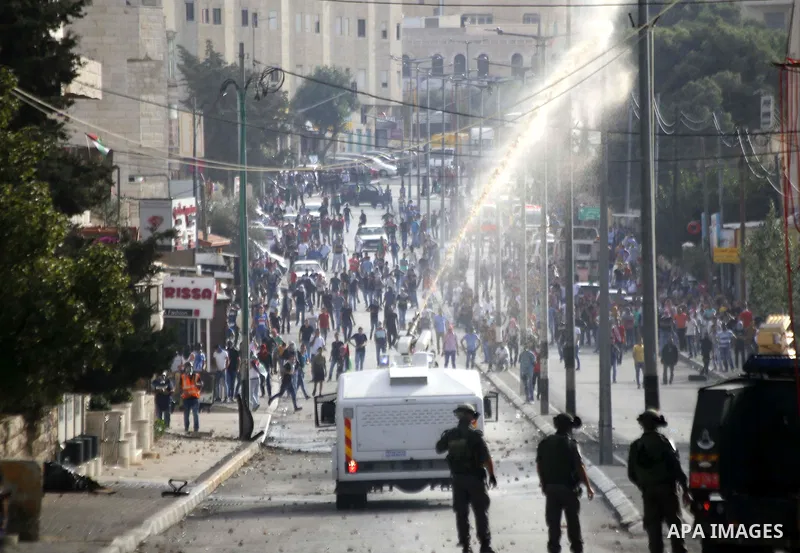 An Israeli military vehicle sprays foul smelling skunk water at Palestinian protesters during clashes in the West Bank city of Bethlehem, on October 13, 2015. A wave of stabbings that hit Israel, Jerusalem and the West B...