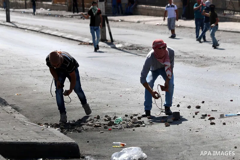 Palestinian protesters use slings to throw stones at Israeli troops during clashes in the West Bank city of Bethlehem October 14, 2015. Seven Israelis and 30 Palestinians, including children and assailants, have been kil...