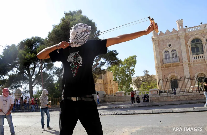 A Palestinian protester uses a sling to throw stones at Israeli troops during clashes in the West Bank city of Bethlehem October 14, 2015. Seven Israelis and 30 Palestinians, including children and assailants, have been...