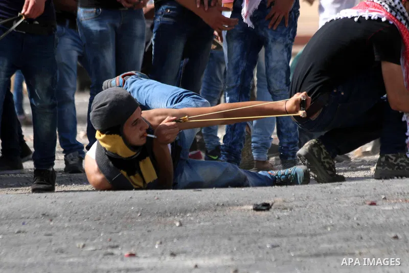 A Palestinian protester uses a sling to throw stones at Israeli troops during clashes in the West Bank city of Bethlehem October 14, 2015. Seven Israelis and 30 Palestinians, including children and assailants, have been...
