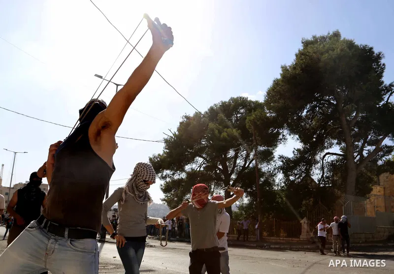 A Palestinian protester uses a sling to throw stones at Israeli troops during clashes in the West Bank city of Bethlehem October 14, 2015. Seven Israelis and 30 Palestinians, including children and assailants, have been...