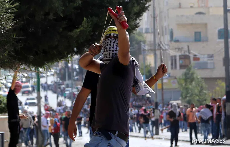 A Palestinian protester uses a sling to throw stones at Israeli troops during clashes in the West Bank city of Bethlehem October 14, 2015. Seven Israelis and 30 Palestinians, including children and assailants, have been...