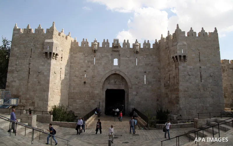 People walk in front of Damascus gate outside the al-Aqsa mosque compound in Jerusalem's Old city on October 14, 2015. Seven Israelis and 30 Palestinians, including children and assailants, have been killed in two weeks...