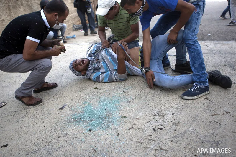 Palestinian protesters help an injured comrade during clashes with Israeli security forces near the Jewish settlement of Bet El, near the West Bank city of Ramallah, on October 14, 2015. Seven Israelis and 30 Palestinian...