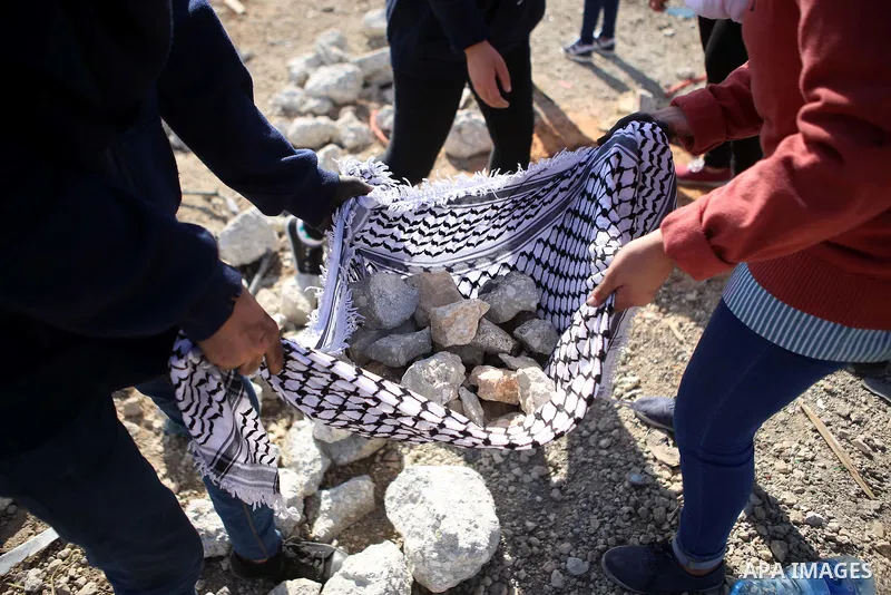 Palestinian female protesters gather stones during clashes with Israeli security forces near the Jewish settlement of Bet El, near the West Bank city of Ramallah, on October 14, 2015. Seven Israelis and 30 Palestinians,...