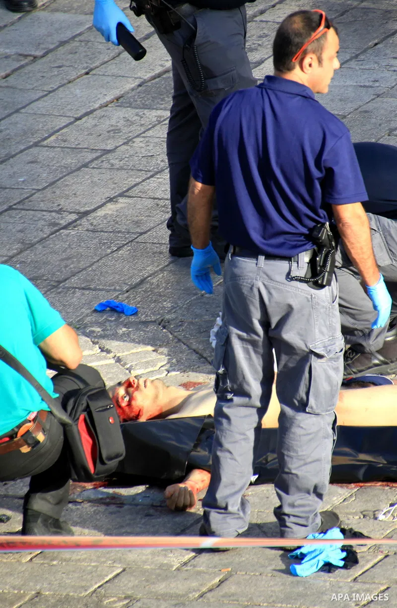 Israeli security forces and forensic police inspect the body of a man who attempted to carry out a knife attack at the Damascus Gate at the entrance of the Old City in east Jerusalem on October 14, 2015. Israeli police s...