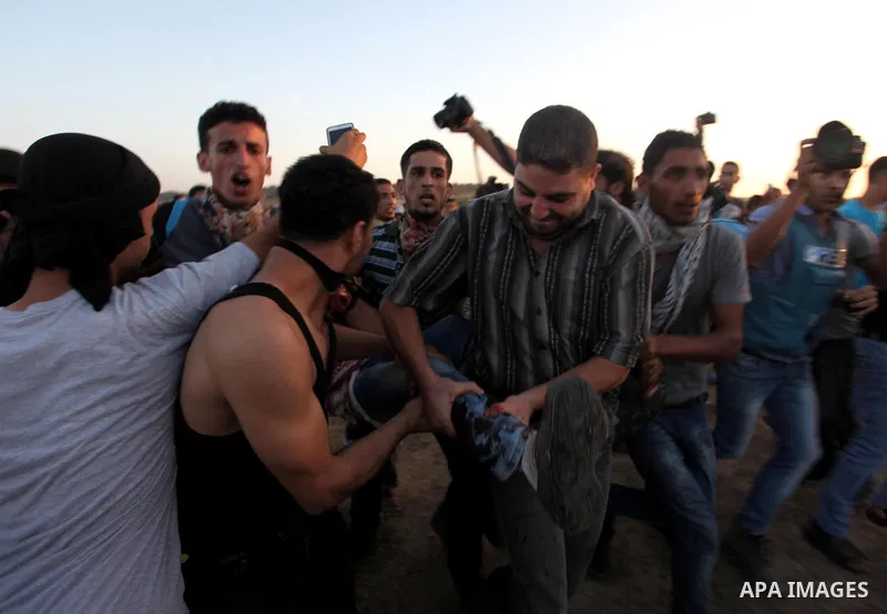 A Palestinian protester is evacuated by comrades after being injured during clashes with Israeli troops near a border fence between Israel and the Gaza Strip on October 14, 2015 east of Bureij in central Gaza. The outbre...