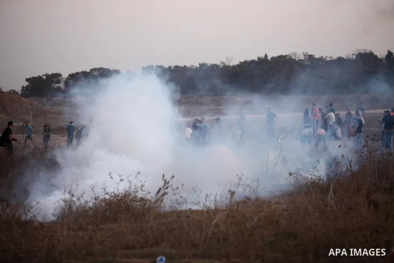 Palestinian protesters run for cover from tear gas during clashes with Israeli troops near a border fence between Israel and the Gaza Strip on October 14, 2015 east of Bureij in central Gaza. The outbreak of violence bet...