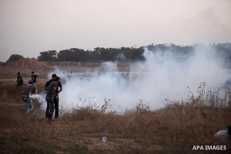 A Palestinian protester throws back a tear gas canister towards Israeli troops during clashes near a border fence between Israel and the Gaza Strip on October 14, 2015 east of Bureij in central Gaza. The outbreak of viol...