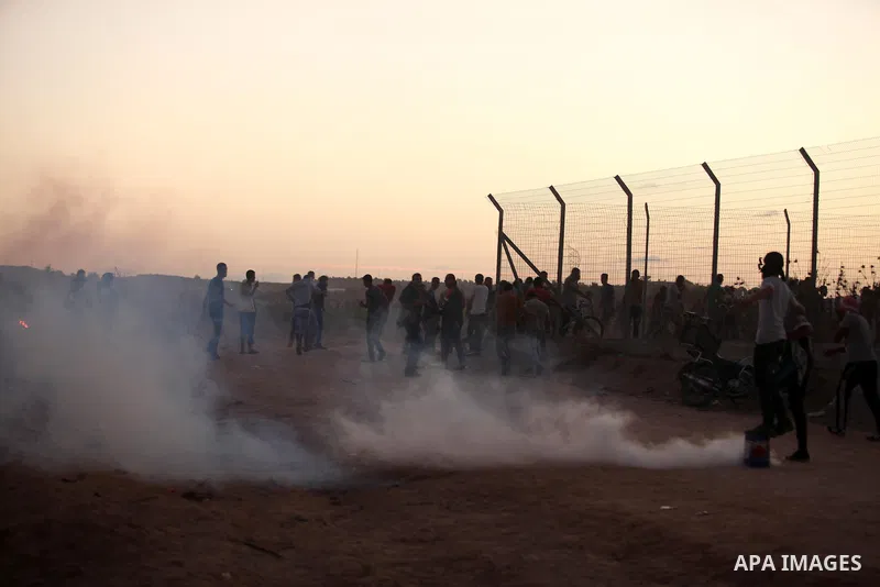 Palestinian protesters run for cover from tear gas during clashes with Israeli troops near a border fence between Israel and the Gaza Strip on October 14, 2015 east of Bureij in central Gaza. The outbreak of violence bet...