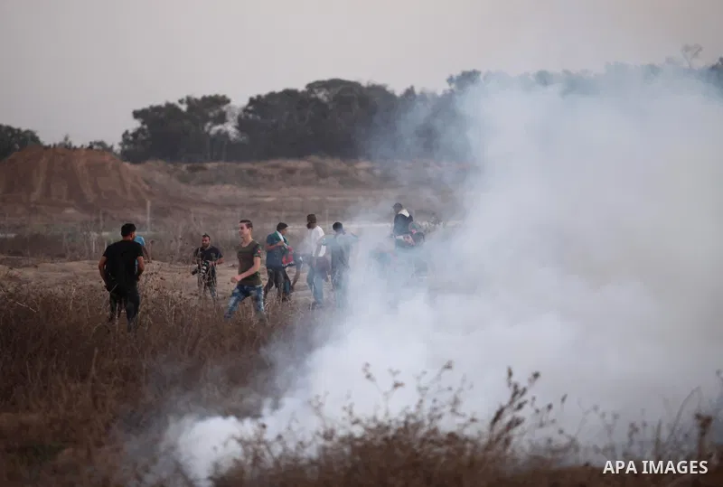 Palestinian protesters run for cover from tear gas during clashes with Israeli troops near a border fence between Israel and the Gaza Strip on October 14, 2015 east of Bureij in central Gaza. The outbreak of violence bet...